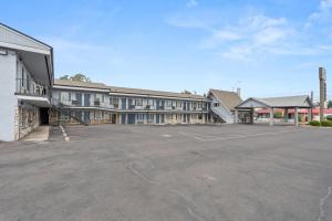 an empty parking lot in front of a building at Pine Tree inn in Medford
