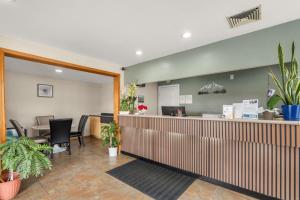 a lobby with a waiting area with plants at Pine Tree inn in Medford