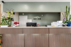 an office with a reception counter with flowers and plants at Pine Tree inn in Medford