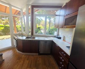 a kitchen with a sink and a large window at Casa Kaçi in Mullini i Danit