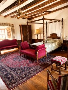 a bedroom with a bed and a couch and a chair at Château de Taussac in Taussac +27 photos