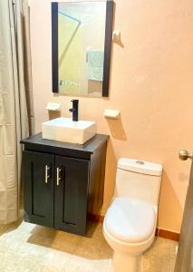 a bathroom with a white toilet and a sink at Accommodation near downtown in San Cristóbal de Las Casas