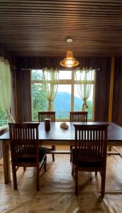 a dining room with a table and chairs and a window at Kepchaki Stay in Takdāh +15 photos