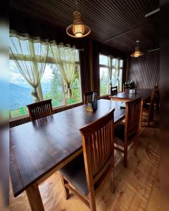a dining room with a large wooden table and chairs at Kepchaki Stay in Takdāh