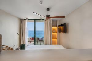 a bedroom with a bed and a view of the ocean at Suites by Miramar - Adults only in Lloret de Mar