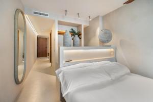 a white bedroom with two beds and a mirror at Suites by Miramar - Adults only in Lloret de Mar +37 photos
