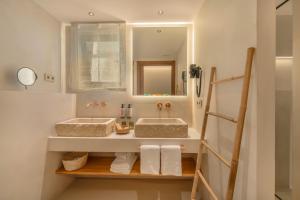 a bathroom with two sinks and a mirror at Suites by Miramar - Adults only in Lloret de Mar