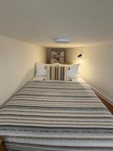 a bed with a striped blanket on it in a room at Tivat Cozy Studio in Tivat