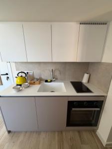 a kitchen with white cabinets and a sink at Tivat Cozy Studio in Tivat