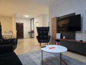 a living room with a black chair and a table at Puzzle Apart Rooms in Tirana
