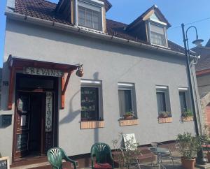a building with chairs and tables in front of it at Revans teázó apartman- belváros in Pápa