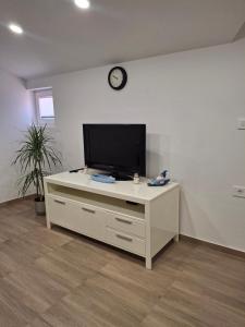 a living room with a television on a white cabinet at Villa Ivana in Koper