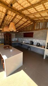 a kitchen with a table and a counter top at Chalé Pontal da Juacema in Ilha Cachoeira +58 photos