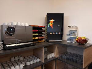 a kitchen with a counter with cups and a refrigerator at Pension Klatovy in Klatovy +15 photos