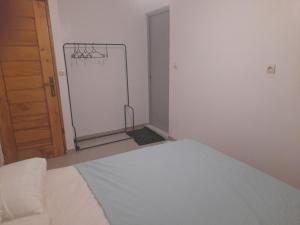 a room with a white bed and a chalkboard at Residence du fromager in Bouaké +3 photos
