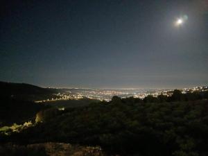 a full moon rising over a city at night at اطلالة سوف in Jerash