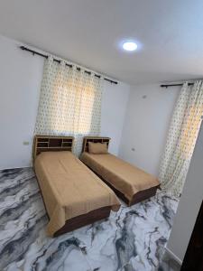 two beds in a bedroom with a marble floor at اطلالة سوف in Jerash