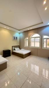 a large room with two beds and two windows at فيلا هابي نايت in Ash Shafa