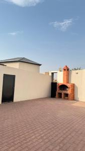 a building with a brick courtyard with a brick oven at فيلا هابي نايت in Ash Shafa