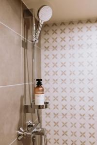 a bottle of soap is sitting on a shelf in a shower at Lavandas apartamenti in Ikšķile +27 photos