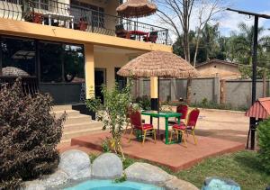 a patio with a table and chairs and an umbrella at Safari Resot Star One in Moshi +27 photos
