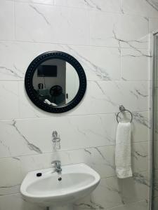 a white bathroom with a sink and a mirror at 4 at Granada 2 in East London +13 photos