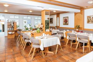 a dining room with white tables and chairs at Hotel Garni Brugger in Lindau