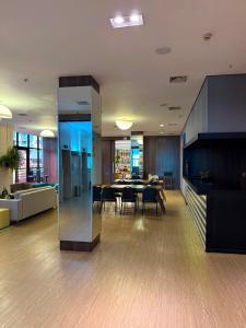 a lobby with a table and a dining room at Lindo Flat Part Grand Mercure Varanda aconchegante in Brasília