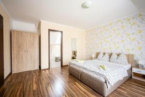 a bedroom with a bed and a wall with yellow flowers at Gere Art&Exclusive Apartments in Harkány