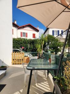 a patio with a table and chairs and an umbrella at Chambre chez Rena in Saint-Jean-de-Luz