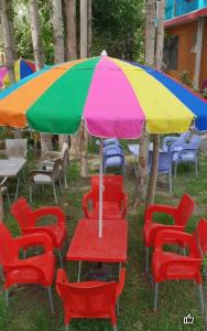 a table and chairs under a colorful umbrella at Royal Brangsa in Skardu