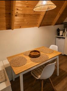 a wooden table with two chairs and a bowl on it at Chechar Inn Zlatar in Nova Varoš