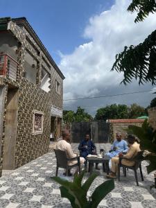 a group of people sitting around a table on a patio at Kala's apartment farato in Medina Suware Kunda