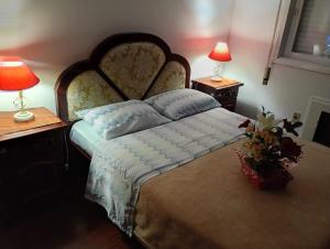 a bedroom with a large bed with two lamps at Conforto no Centro in Pelotas +13 photos