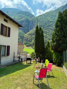 a yard with chairs and tables with mountains in the background at Casa Lucini in Campascio