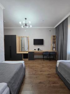 a hotel room with two beds and a desk and a television at TOI AT-BASHY HOTEl in At-Bashy