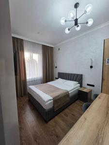 a bedroom with a bed and a chandelier at TOI AT-BASHY HOTEl in At-Bashy