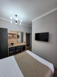a bedroom with a bed and a desk and a television at TOI AT-BASHY HOTEl in At-Bashy