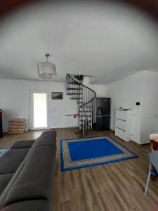 a living room with a couch and a spiral staircase at Casa Curcubeu in Ceahlău