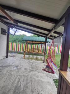 a porch with a swing and a playground at Casa Curcubeu in Ceahlău
