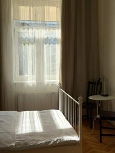 a bedroom with a bed and a window and a table at Cent Hostel - Lublin Centrum in Lublin