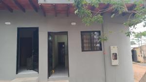 a white building with two doors on the side at Monoambiente en villa Elisa in Villa Elisa