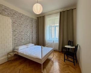 a bedroom with a bed and a brick wall at Cent Hostel - Lublin Centrum in Lublin