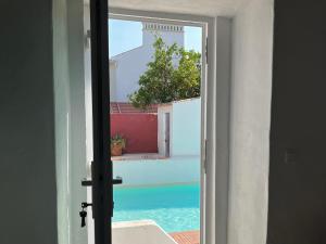an open door with a view of a pool at Casa do Caseiro by Quinta da Burra in Cartaxo