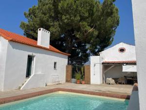 a villa with a swimming pool in front of a house at Casa do Caseiro by Quinta da Burra in Cartaxo