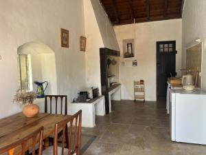 a kitchen with a wooden table and a refrigerator at Casa do Caseiro by Quinta da Burra in Cartaxo