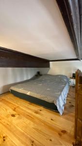 a bed in a room with a wooden floor at Studio in Saint-Martin-Vésubie +7 photos