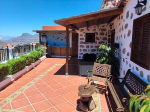 a patio with a bench on a house at Casita Roque Nublo in Tejeda