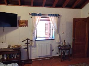 a living room with a window and a television at Casita Roque Nublo in Tejeda