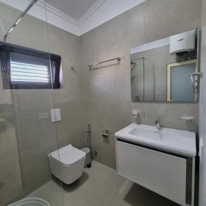a bathroom with a toilet and a sink and a mirror at Kypsel Apartment in Durrës +73 photos